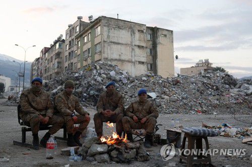 모닥불 앞에서 몸 녹이는 튀르키예 군인들(이스켄데룬 로이터=연합뉴스) 16일(현지시간) 튀르키예 남부 하타이주 이스켄데룬에서 군인들이 모닥불 앞에 앉아 몸을 녹이고 있다. 지난 6일 시리아와 인접한 튀르키예 남동부에서 규모 7.8의 강진이 발생해 현재까지 양국에서 집계된 사망자 수는 4만1천명을 넘어섰다. 2023.02.16 ddy04002@yna.co.kr