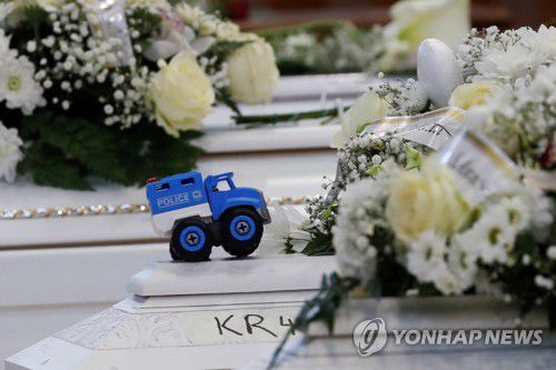 아기 시신이 든 흰색 관 위에 놓인 장난감 트럭[로이터=연합뉴스]