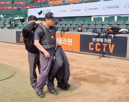 장비 착용하는 심판(대전=연합뉴스) 김경윤 기자 = 대한야구소프트볼협회 김원재 심판위원(오른쪽)이 28일 대전한화생명이글스파크에서 열린 자동 볼·스트라이크 판정시스템(로봇심판) 시연회에서 장비를 착용하고 있다. cycle@yna.co.kr 2023.3.28.