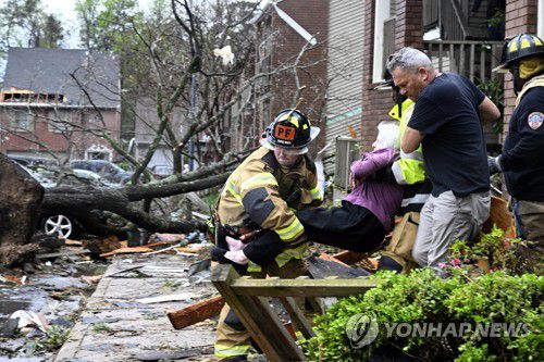 토네이도로 무너진 건물에서 구조되는 피해 주민(AP=연합뉴스) 31일(현지시간) 미국 아칸소주 리틀록에서 소방대원들이 한 여성을 실어 나르고 있다. 2023.3.31 [재판매 및 DB 금지]