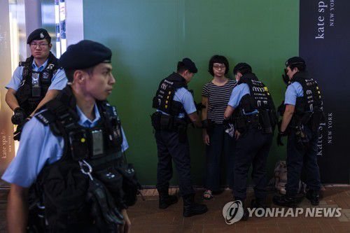 (AP=연합뉴스) 톈안먼 민주화시위 34주년을 하루 앞둔 지난 3일 저녁 홍콩 번화가 코즈웨이베이에서 경찰이 시민을 검문하는 모습. 2023.6.4.
