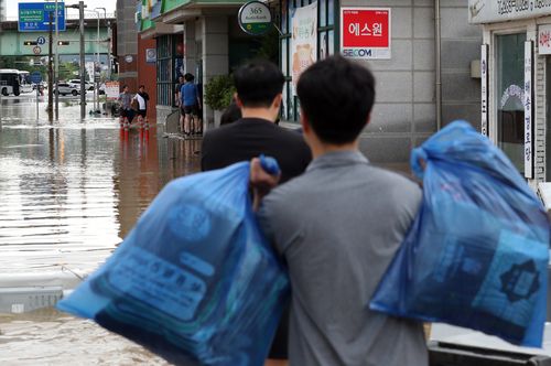 흙탕물 뚫고 출근(목포=연합뉴스) 정회성 기자 = 24일 오전 전남 목포시 석현동 시가지에서 금융기관 직원들이 폭우에 침수된 거리를 줄지어 걸으며 출근하고 있다. 2023.7.24 hs@yna.co.kr