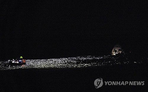 수면에 착륙한 '크루 드래건' 우주선에 구조대가 접근한 모습[AP 연합뉴스 자료사진]