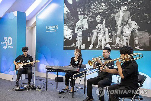 삼성화재 안내견학교 30주년 기념식(서울=연합뉴스) 19일 경기 용인시 삼성화재 안내견학교에서 열린 삼성화재 안내견학교 30주년 기념식에서 국민의힘 김예지 의원을 비롯한 안내견 파트너들이 축하 연주를 하고 있다. 2023.9.19 [삼성전자 제공. 재판매 및 DB 금지] photo@yna.co.kr