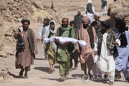 아프간 헤라트 강진에 희생된 아들 주검을 안고 가는 주민[로이터 연합뉴스 자료사진. 재판매 및 DB 금지]