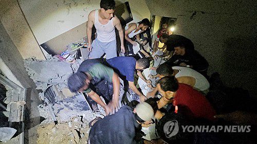 가자지구 자발리아 난민촌의 한 건물 잔해 속에서 아이를 구조하는 주민들[로이터=연합뉴스]