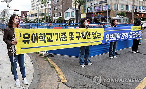 "유보통합 강행 중단하라"(제주=연합뉴스) 전지혜 기자 = 6일 교육부 주최 '유·보 및 유·초 이음교육 전국 현장 공감 공유회'가 열린 제주시 라마다프라자호텔 앞에서 제주교사노동조합 소속 유치원 교사 등 교원들이 유보통합에 반대하는 내용의 현수막을 들고 있다. 2023.11.6 atoz@yna.co.kr