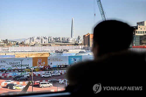 강남 내려다보는 탈북민(AFP=연합뉴스) 지난 1일 서울 강남구 코엑스에서 열린 북한이탈주민 취업 박람회에 참석한 할 탈북민이 거리를 내다보고 있다. 2023.12.6