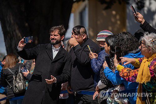 국민투표 후 지지자들과 사진 찍는 칠레 대통령(푼타아레나스 EPA=연합뉴스) 가브리엘 보리치 칠레 대통령(왼쪽)이 17일(현지시간) 푼타아레나스에 마련된 신헌법 국민투표장에서 투표 후 밖에서 지지자들과 사진을 찍고 있다. 2023.12.18 [칠레 대통령실 제공. 재판매 및 DB 금지]