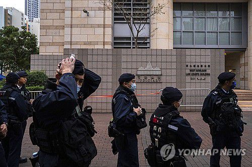 (AP=연합뉴스) 지난 19일 홍콩 반중매체 빈과일보의 사주 지미 라이의 국가보안법 재판이 진행된 홍콩 서구룡 법원 앞을 경찰이 지키고 있는 모습. 2023.12.21.