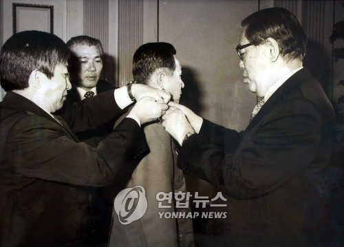 최규하 대통령이 '신군부 5인방' 이희성 신임 육군참모총장에게 계급장을 달아주는 모습[연합뉴스 자료사진]