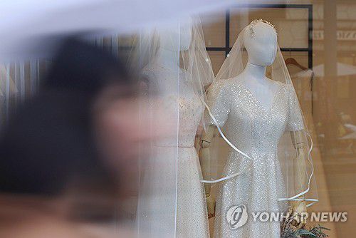 웨딩드레스서울 마포구 아현동 웨딩거리 한 웨딩드레스 판매점 앞을 시민들이 지나가고 있다.2023.12.11 [연합뉴스 자료사진]