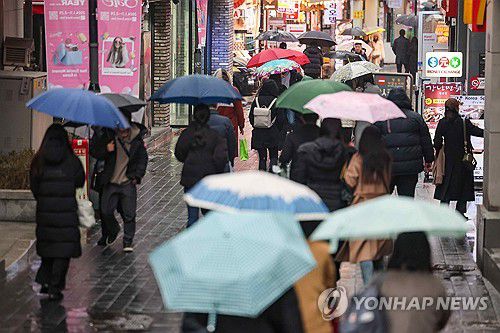 서울 명동거리(서울=연합뉴스) = 비가 내린 14일 오후 서울 중구 명동거리에서 시민들이 우산을 쓰고 이동하고 있다. 2024.1.14 [연합뉴스 자료사진]