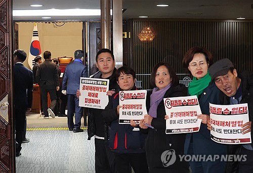 "중대재해처벌법 유예 안됩니다!"(서울=연합뉴스) 신준희 기자 = 1일 국회에서 열린 더불어민주당 의원총회 앞에서 정의당과 노동계 관계자들이 회의장으로 향하는 의원들을 향해 중대재해처벌법 유예 반대 입장을 피력하고 있다.     더불어민주당은 이날 본회의 전 의원총회를 열고 국민의힘이 제시한 중처법 최종 협상안을 논의한다. 2024.2.1 hama@yna.co.kr