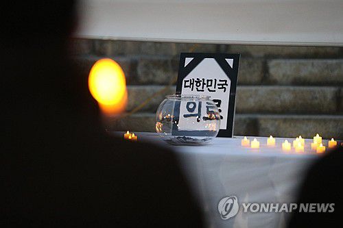 촛불 든 의사들(춘천=연합뉴스) 박영서 기자 = 22일 오후 강원도청 앞에서 강원도의사회가 의대 정원 증원과 필수 의료 정책 패키지 강행을 규탄하는 결의대회를 열어 의료 영결식 퍼포먼스를 하고 있다. 2024.2.22 conanys@yna.co.kr