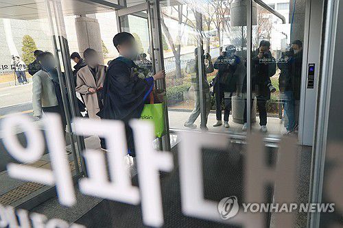 이동하는 의대 졸업생(서울=연합뉴스) 신현우 기자 = 26일 학위수여식이 열린 서울 시내 한 의과대학에서 졸업생이 의대 건물로 들어가고 있다. 2024.2.26 nowwego@yna.co.kr