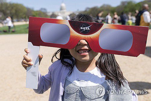 8일(현지시간) 미국 워싱턴DC에서 일식 안경을 쓰고 웃고 있는 어린이[AP=연합뉴스. 재판매 및 DB 금지]