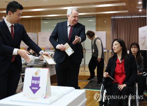 '먼저 하세요'(서울=연합뉴스) 김도훈 기자 = 4·10 총선 사전투표가 시작된 5일 오전 서울 여의동주민센터에서 국민의힘 비례대표 위성정당인 국민의미래 인요한 선거대책위원장이 최보윤 후보에게 순서를 양보하고 있다. 2024.4.5 superdoo82@yna.co.kr