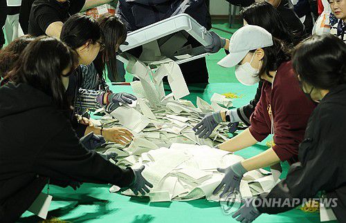 쏟아지는 투표용지(울산=연합뉴스) 김용태 기자 = 제22대 국회의원 선거일인 10일 오후 울산시 남구 문수체육관에 마련된 개표소에서 개표 작업이 이뤄지고 있다. 2024.4.10 yongtae@yna.co.kr