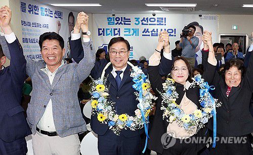 당선 확정 뉴스에 환호하는 서귀포 위성곤 후보(서귀포=연합뉴스) 김호천 기자 = 제22대 국회의원 선거 제주 서귀포시 지역구에 출마한 더불어민주당 위성곤 후보가 당선 확정 방송 보도가 나온 뒤 선서사무실에서 가족과 함께 화환을 목에 걸고 손을 들어 환호하고 있다. 2024.4.11 khc@yna.co.kr