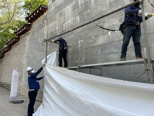 경복궁 영추문 앞에 다시 설치된 가림막     (서울=연합뉴스) 김예나 기자 = 18일 서울 종로구 경복궁 영추문에서 지난해 말 스프레이 낙서로 훼손된 궁궐 담장의 추가 보존 처리 작업을 위한 가림막이 설치되고 있다. 2024.4.18     yes@yna.co.kr