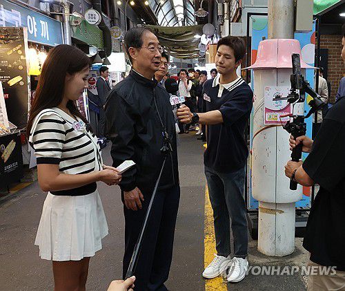 시장에서 방송하는 한덕수 총리(서울=연합뉴스) 최재구 기자 = 한덕수 국무총리가 20일 서울 종로구 통인시장을 방문해 상인들을 격려하며 홈쇼핑 채널에 출연해 인터뷰하고 있다. 2024.5.20