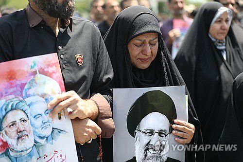 23일(현지시간) 이란 마슈하드 거리에 나서 라이시 대통령을 추모하는 시민들[AFP=연합뉴스 자료사진. 재판매 및 DB 금지]