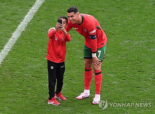 그라운드에 뛰어들어 크리스티아누 호날두와 사진을 찍는 소년 팬[로이터=연합뉴스]