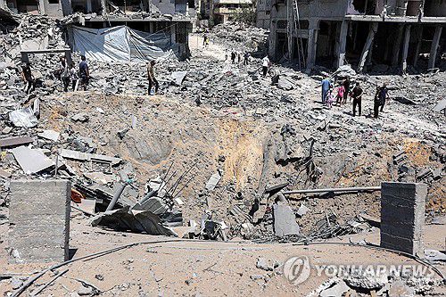 이스라엘군의 폭격으로 생긴 거대한 구덩이를 살피는 팔레스타인 주민들[AFP 연합뉴스자료사진. 재판매 및 DB 금지]