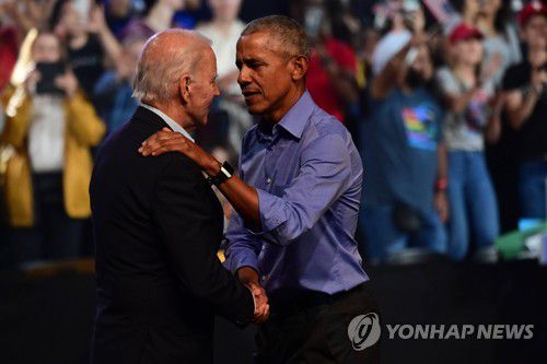 조 바이든 대통령(좌측)과 악수하는 버락 오바마 전 대통령(우측)[AFP 연합뉴스 자료사진]