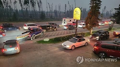캐나다 로키산맥 인근 도시 재스퍼를 덮친 산불을 피해 대피하는 차량 행렬 [AFP 연합뉴스 자료사진]