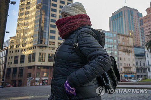 '남반구는 겨울' 지난 11일(현지시간) 몬테비데오 도심 걸어가는 여성[AFP 연합뉴스 자료사진. 재판매 및 DB 금지]