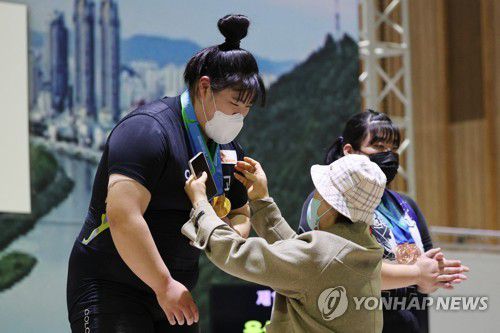 박혜정 목에 걸린 3개의 금메달(울산=연합뉴스) 임화영 기자 = 8일 오전 울산전시컨벤션센터(UECO)에서 열린 제103회 전국체육대회 역도 여자 고등부 87kg이상급 시상식에서 인상·용상·종합 1위를 한 박혜정(안산공고)이 어머니께 금메달을 수여받고 있다. 2022.10.8 hwayoung7@yna.co.kr