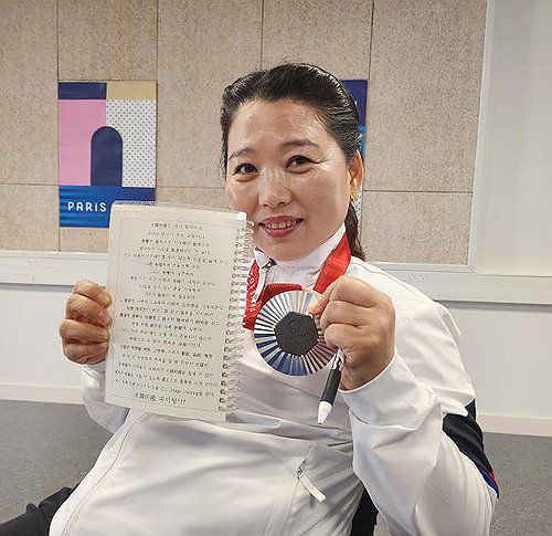 훈련일지와 은메달 보여주는 이윤리(샤토루[프랑스]=연합뉴스) 장애인 여자 사격 간판 이윤리가 30일(한국시간) 프랑스 샤토루 슈팅센터에서 열린 2024 파리 패럴림픽 사격 R2 여자 10ｍ 공기소총 입사(스포츠등급 SH1)에서 은메달을 획득한 뒤 자신의 훈련일지와 은메달을 보여주며 활짝 웃고 있다. 2024.8.30 [대한장애인체육회 제공. 재배포 및 DB 금지]