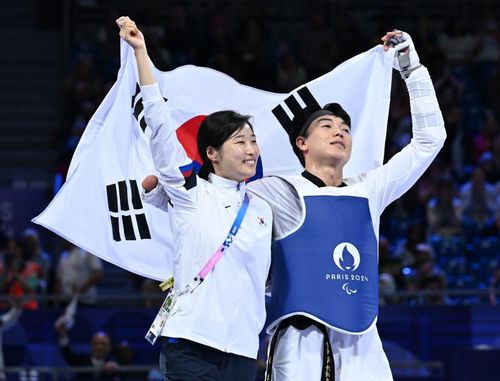 태극기 든 주정훈(파리=연합뉴스) 공동취재단 = 장애인 태권도 주정훈(오른쪽)이 1일(한국시간) 프랑스 파리 그랑팔레에서 열린 2024 파리 패럴림픽 태권도 남자 80㎏급 스포츠등급 K44 동메달 결정전에서 승리한 뒤 태극기를 들고 기뻐하고 있다. 왼쪽은 김예선 감독. 2024.9.1.