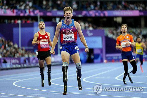 우드홀, 남자 400ｍ 우승(파리 AFP=연합뉴스) 헌터 우드홀(가운데)이 7일(한국시간) 프랑스 파리 스타드 드 프랑스에서 열린 2024 파리 패럴림픽 육상 남자 400ｍ(T64) 결선에서 우승한 뒤 포효하고 있다.
