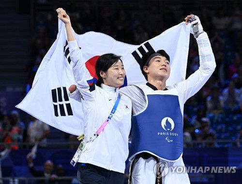 주정훈 (2024.9.1)(파리=연합뉴스) 공동취재단 = 장애인 태권도 주정훈(오른쪽)이 1일(한국시간) 프랑스 파리 그랑팔레에서 열린 2024 파리 패럴림픽 태권도 남자 80㎏급 스포츠등급 K44 동메달 결정전에서 승리한 뒤 태극기를 들고 기뻐하고 있다. 왼쪽은 김예선 감독. 2024.9.1.