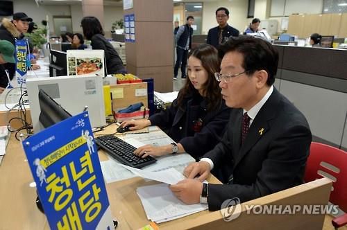 청년배당 지급하는 이재명 시장(성남=연합뉴스) 2016년 12월 26일 경기도 성남시 중원구 하대원동 주민센터에서 이재명 당시 성남시장이 청년배당 지급 업무를 돕고 있다. 성남시는 정부와의 소송으로 유보했던 '3대 무상복지'(청년배당·산후조리·무상교복) 지원금 절반을 이날부터 지급했다. 2016.12.26 [성남시 제공 자료사진. 재판매 및 DB 금지]