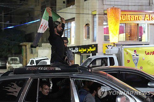 나스랄라의 죽음에 기뻐하는 시리아인들(이들리브 AFP=연합뉴스) 27일(현지시간) 밤 하산 나스랄라의 사망 소식이 알려진 직후 이들리브의 한 시민이 시리아 반군 깃발을 들고 있다. 2024.09.29