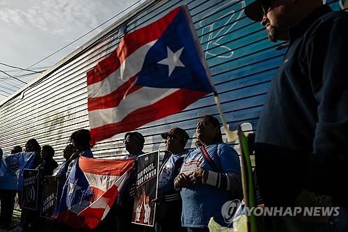 트럼프 유세장 근처서 푸에르토리코 깃발들고 항의하는 사람들[알렌타운[미 펜실베이니아주] AFP=연합뉴스. 재판매 및 DB 금지]