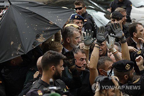 진흙을 던지는 주민들(발렌시아 EPA=연합뉴스) 3일(현지시간) 수해가 난 스페인 발렌시아를 방문한 필리페6세(가운데) 국왕이 주민들이 던지는 진흙을 피하고 있다. 2024.11.3