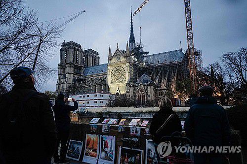 화마를 딛고 재개관한 파리 노트르담 대성당(파리 AFP=연합뉴스) 4일(현지시간) 프랑스 파리 시내 노트르담 대성당 주변에서 행인들이 재개관한 대성당의 사진을 찍고 있다. 2024.12.5