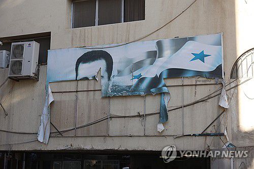찢긴 바샤르 알아사드 대통령 초상화(다마스쿠스 EPA=연합뉴스) 8일(현지시간) 반군이 점령한 수도 다마스쿠스의 건물에 걸려있든 알아사드 대통령의 초상화가 찢겨있다. 2024.12.09