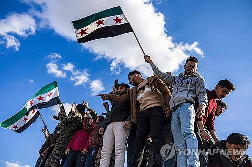 시리아 독립기(AFP 연합뉴스) 13일(현지시간) 시리아 수도 다마스쿠스의 우마이야드 광장에 알아사드 정권 축출을 자축하는 인파가 몰렸다. 2024.12.14 dk@yna.co.kr
