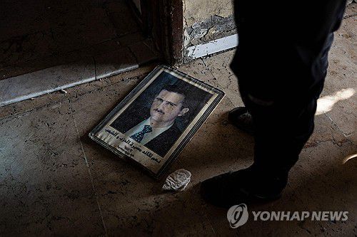 바닥에 떨어진 아사드 전 대통령 초상화[AFP=연합뉴스 자료사진]