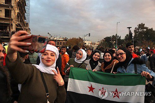 시리아 깃발 들고 사진 찍는 다마스쿠스 시민들[AFP=연합뉴스]