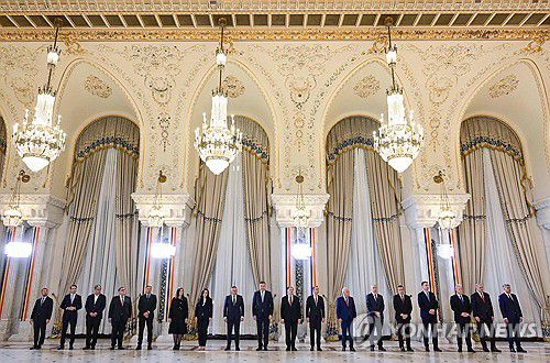 루마니아 새 정부 출범(부쿠레슈티 AFP=연합뉴스) 마르첼 치올라쿠 총리를 비롯해 루마니아의 새 내각이 23일(현지시간) 수도 부쿠레슈티에 있는 대통령궁에서 열린 취임 선서식에 모여 있다. 2024.12.23 photo@yna.co.kr