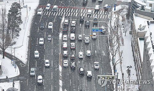 눈 내리는 대구(대구=연합뉴스) 윤관식 기자 = 대구에 눈이 내린 7일 대구 중구 달구벌대로에서 차량들이 서행하고 있다. 2025.2.7 psik@yna.co.kr