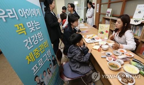 하루 권장 식사량 알아보아요!    (서울=연합뉴스) 김주형 기자 = 비만예방 건강생활 체험교실 '우리 아이 건강 디자인'행사가 열린 서울시 교육청에서 23일 오전 참가 어린이와 학부모가 하루 권장 식사 섭취량에 대해 상담하고 있다. 2016.4.23     kjhpress@yna.co.kr