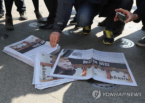 [대통령 탄핵] 박 전 대통령 파면 다룬 신문(서울=연합뉴스) 이지은 기자 = 헌법재판소의 탄핵인용 결정으로 박근혜 전 대통령이 자연인 신분으로 돌아간 10일 오후 서울 광화문광장에 놓쳐진 한 석간신문을 시민들이 가져가고 있다. 2017.3.10 jieunlee@yna.co.kr